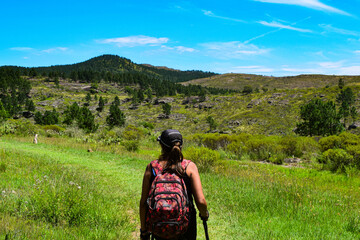 Mujer de mediana edad haciendo trekkings en sierras de córdoba camino a una cascada con hermosa...