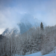 Montagne enneigée en hiver avec de la brume dans les alpes françaises dans la vallée de l'Oisans