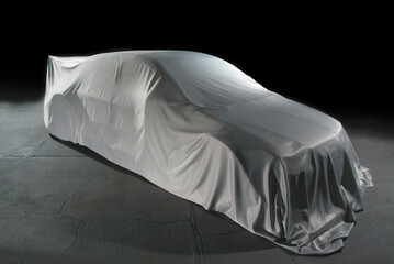 racing car in garage covered with fabric