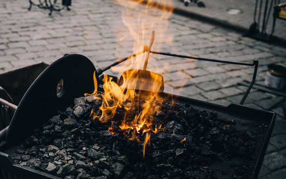 A blacksmith working with simple object by forging the metal. Flame texture close-up. Art, traditional craft, handicraft, history, industry, smithing process, wrought iron and steel details - Powered by Adobe