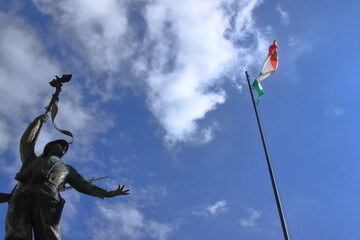bronze statue of Italian partisan in front of the tricolor flag