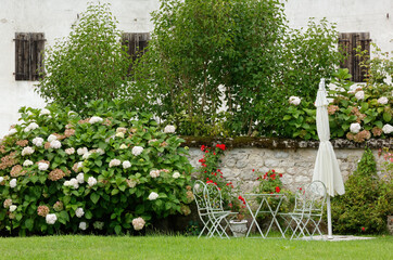 Lovely corner of a garden, with a small table, chairs and a parasol