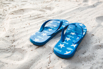 Fototapeta na wymiar Blue flipflop shoes on white sand beach