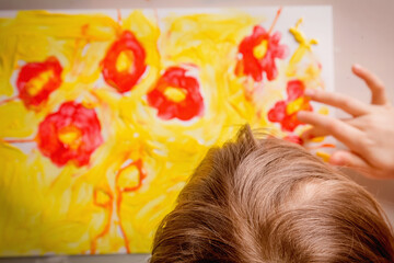 Naklejka premium Top view of cute little child girl painting flowers. Selective focus.