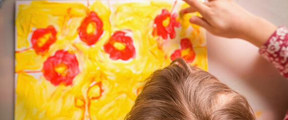 Top view of cute little child girl great artist painting flowers. Selective focus on hair of child.
