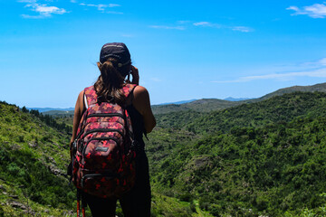 Mujer de mediana edad haciendo trekkings en sierras de córdoba camino a una cascada con hermosa...