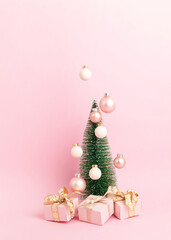 Fototapeta na wymiar Christmas tree with ornaments over pink background. Minimal picture for winter holidays