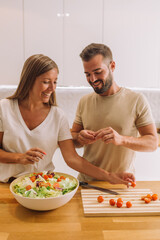 young couple laughing and working together with copy space in a nice kitchen 