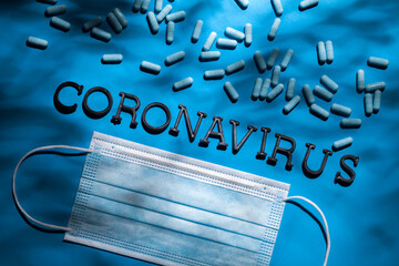 Medical mask on a blue background. Protection against the coronavirus COVID-19 SARS-CoV-2. Personal protective equipment for breathing