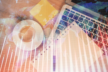 Double exposure of forex chart drawing over table background with computer. Concept of financial...