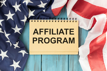 Fototapeta na wymiar Affiliate Marketing written on paper, wood table background with American backdrop. Conceptual top view.