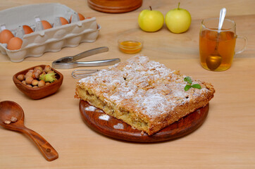 homemade pie on the table and ingredients for cooking hazelnuts and apples and eggs