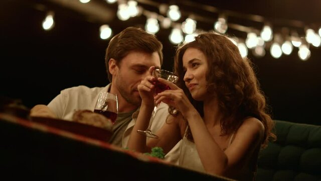 Man flirting with woman at romantic date. Cheerful couple talking together
