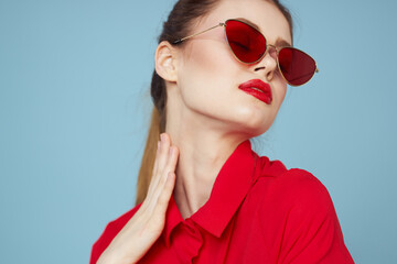 portrait of a woman with glasses and red lips shirt blue background model