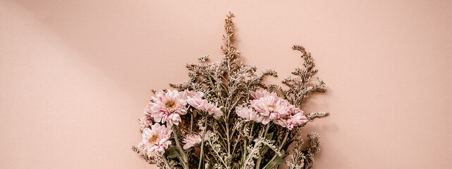 Schöner Blumenstrauß aus rosa Chrysanthemenblumen auf blassrosa beigefarbenem Hintergrund. Trendiges minimalistisches horizontales Banner mit Platz für Text. © Svetlana Glazkova