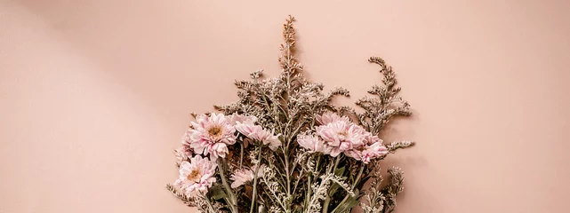 Schöner Blumenstrauß aus rosa Chrysanthemenblumen auf blassrosa beigefarbenem Hintergrund. Trendiges minimalistisches horizontales Banner mit Platz für Text. © Svetlana Glazkova