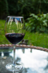 
Glass with red wine on a transparent glass table
