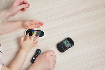grandmother is doing glucose level finger blood test to child