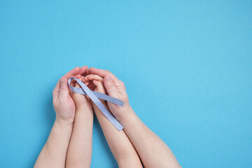 grandmother and granddaughter hold a blue ribbon on a blue background,