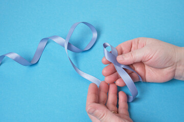 grandmother and granddaughter hold a blue ribbon on a blue background,