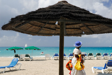 Little Bay Vendor walking under a beach umbrella