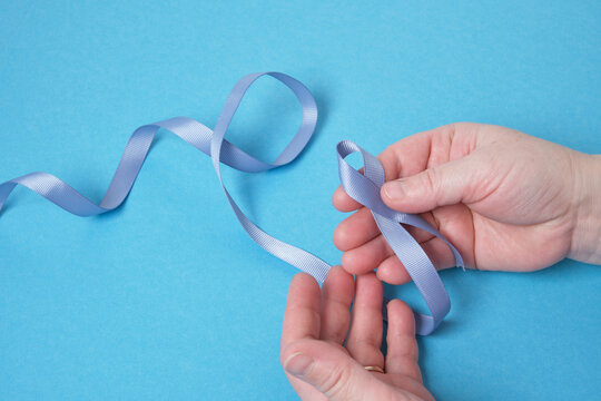 grandmother and granddaughter hold a blue ribbon on a blue background,
