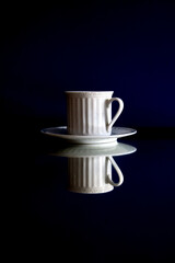 blue background cup and dish with reflection, dark,  light and shadows