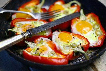 Selective focus. Red peppers with eggs baked in a frying pan. The keto diet. Keto lunch idea.