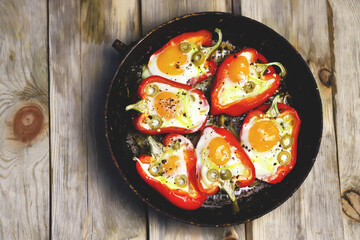 Selective focus. Red peppers with eggs baked in a frying pan. The keto diet. Keto lunch idea.