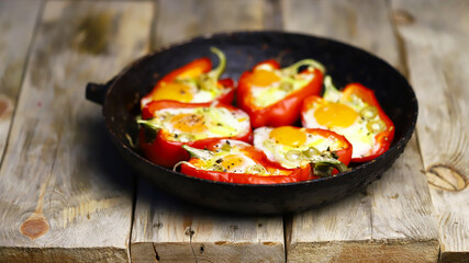 Selective focus. Red peppers with eggs baked in a frying pan. The keto diet. Keto lunch idea.
