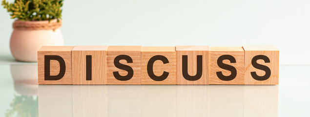 Discuss motivation text on wooden blocks business concept white background. Front view concepts, flower in the background.