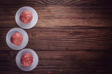 Ground beef balls for hamburger with wood background and copy space - Top view