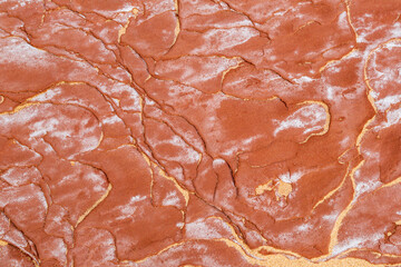 A red or orange sandstone beach on Canada's Prince Edward Island is weathered with yellow sand and ocean salt to create a stunning pattern from eons of erosion