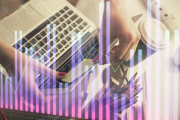 Plakat Double exposure of businesswoman hands typing on computer and financial graph hologram drawing. Stock market analysis concept.