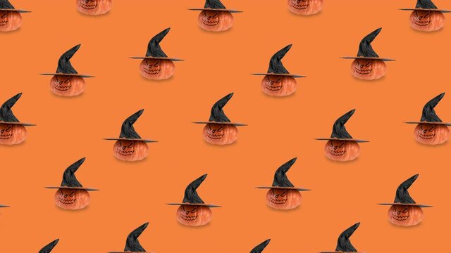 seamless looping animation with pattern of orange pumpkins. scary smile and black witch hat rotating close-up. Halloween concept on background with copy space