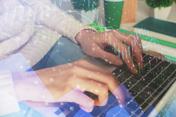 Double exposure of woman hands typing on computer and forex chart hologram drawing. Stock market invest concept.