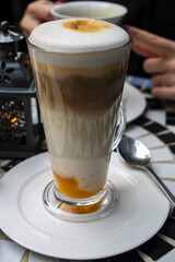 Latte in a transparent glass is on the table