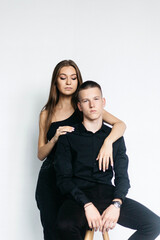 Man and woman kissing each other on a black background. The girl bites the guy on the nose. Black background Guy and girl holding hands. Couple hugging. Love.