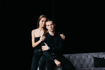 Man and woman kissing each other on a black background. The girl bites the guy on the nose. Black background Guy and girl holding hands. Couple hugging. Love.