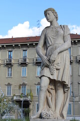 Statua di una donna con un grappolo d'uva durante la vendemmia