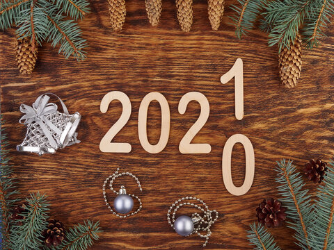 New year's background.On a wooden background are figures surrounded by pine branches ,cones and Christmas toys.