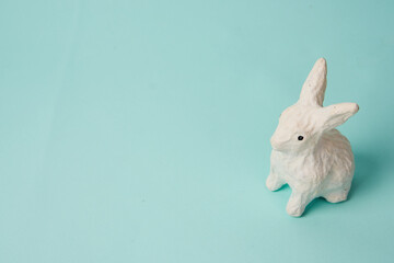 Festive white rabbit toy on a blue background with pastel colors Easter