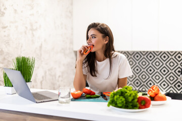 Obraz na płótnie Canvas Young pretty woman use laptop in the kitchen