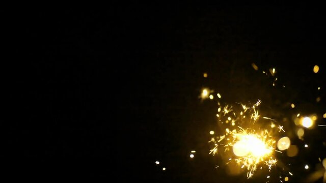 Slow motion shot of Firework sparkler burning on black backround
