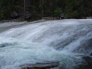 River cascading over smooth rock at top of waterfall in Yosemite Valley, USA
