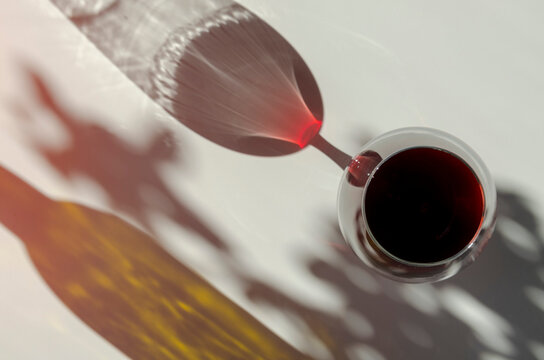 Glass Of Red Ruby Port Wine On White Table With Shadows