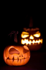 two pumkins for halloween, glowing and not glowing