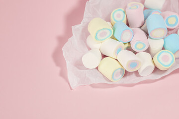 Marshmallow sweets in light colors on pink background, with free copy space