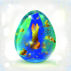 This blue glass egg is decorated with a golden pattern of hares and floral designs. Easter egg on a light background with bokeh effect.