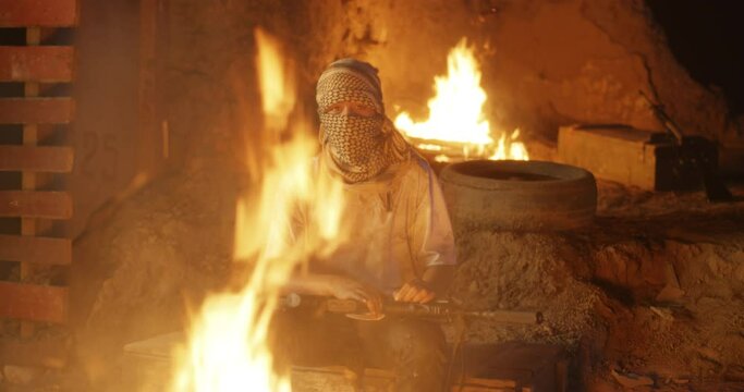 Young terrorist with gun near fire